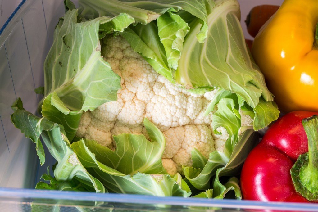 Open fridge filled with fruits and vegetables.