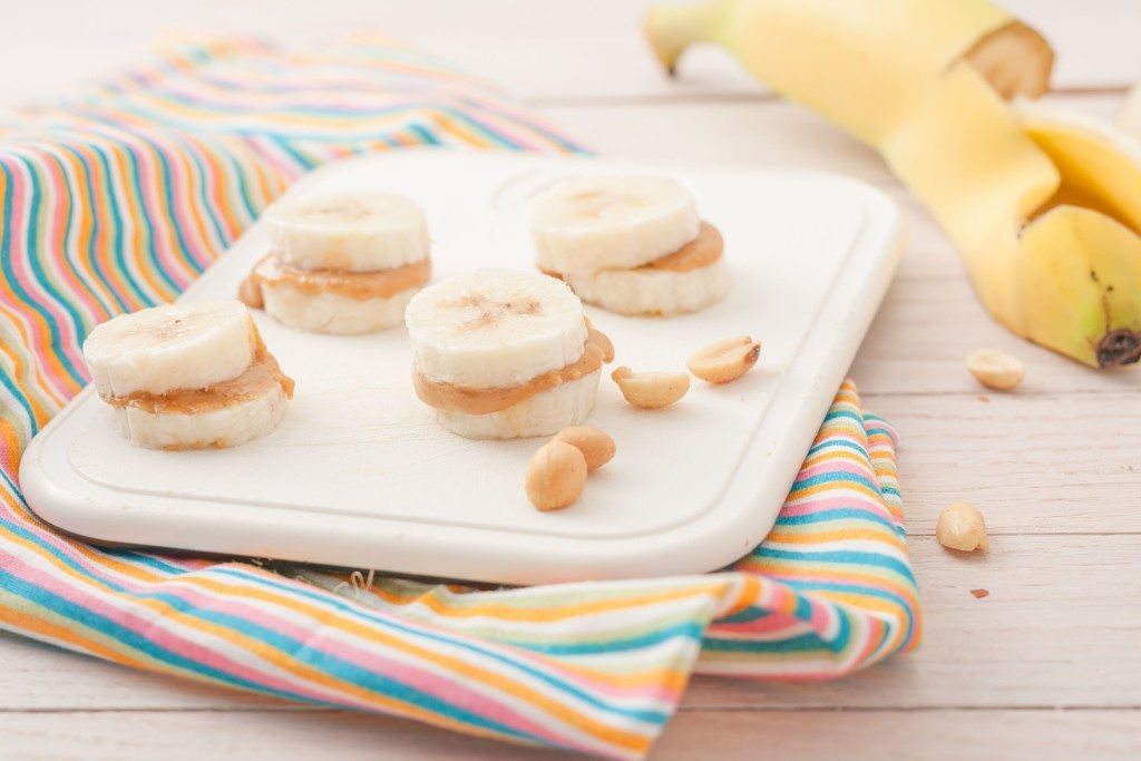 banana slices with peanut butter on white chopping board