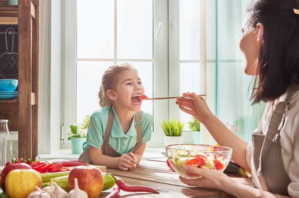 A image of mom feeding her daughter.