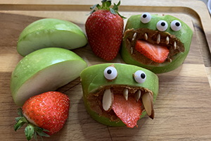 Green Goblin apple bites on a cutting board for Halloween