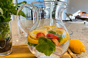 strawberry, basil and lemon infused water in a pitcher on the table